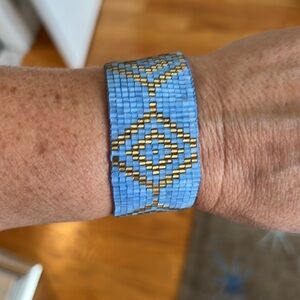 Beaded bracelet in periwinkle and gold. Adjustable sizing with tie.